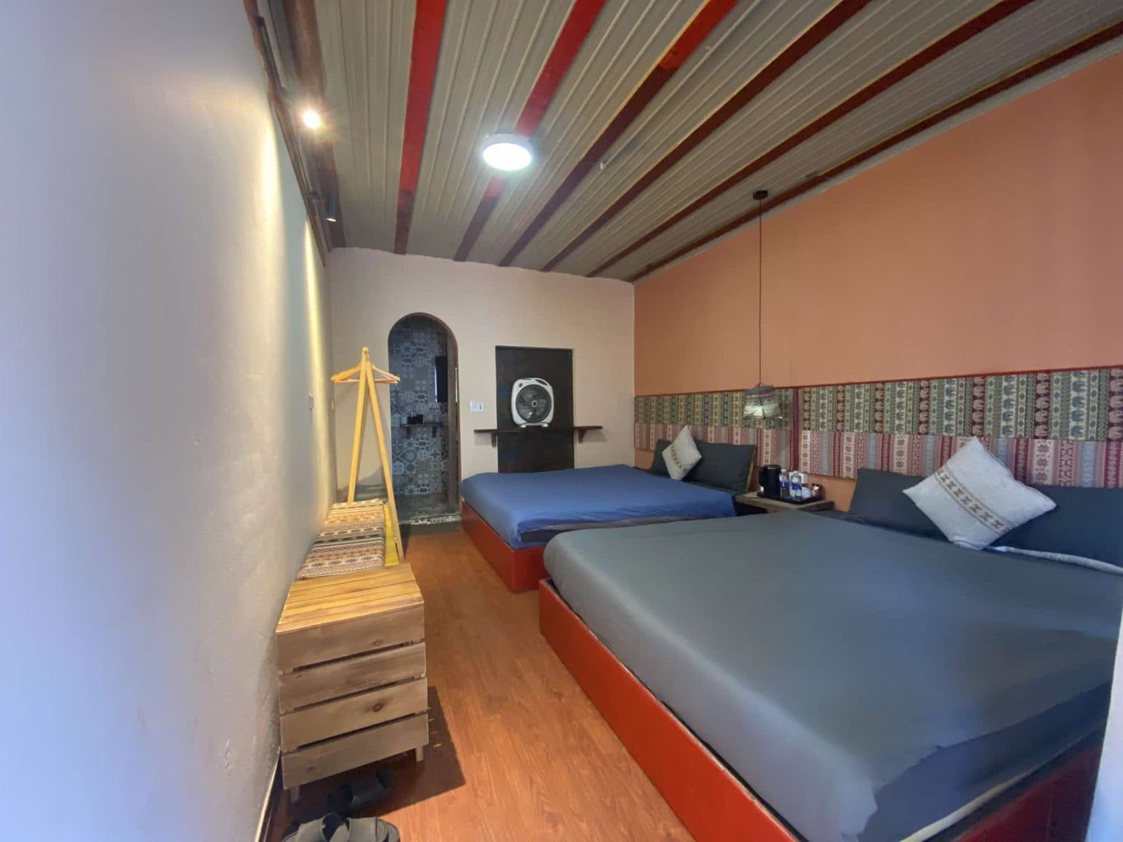 Phòng Cozy Family với hai giường lớn và đầu giường thổ cẩm.